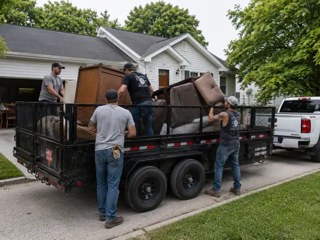Local junk removal crew loading furniture into a trailer in Lenawee County